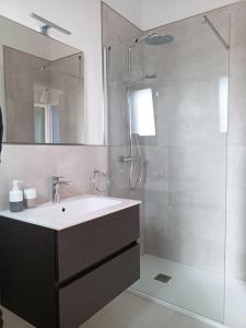 uma casa de banho com um lavatório e um chuveiro em Casa Giuseppe Castelsardo em Castelsardo
