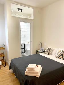 1 dormitorio con 1 cama con toallas en Barcelona PR Guesthouse, en El Prat de Llobregat