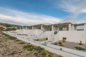 a building with white walls and stairs in a field at Sunset Village 3 in Paleochori