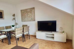 salon z telewizorem z płaskim ekranem i stołem w obiekcie Apartamento Porto do Xufre w mieście Isla de Arosa