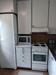 a kitchen with white appliances and a white refrigerator at Saunallinen rivitalo yksiö in Heinävesi