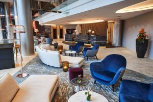 a lobby of a hotel with couches and chairs at Steigenberger Hotel Hamburg in Hamburg