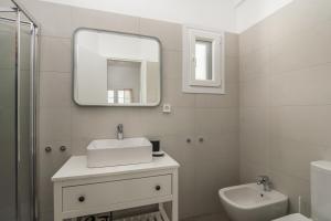 a white bathroom with a sink and a mirror at Sunset Village 3 in Paleochori