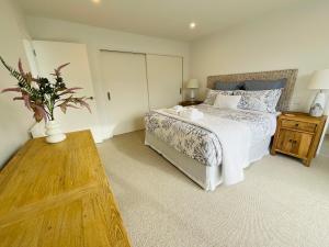 a bedroom with a bed and a vase with a plant at Deluxe Downtown Mount Maunganui in Mount Maunganui