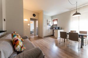 un soggiorno e una cucina con divano e tavolo di Top Living Apartments - Appartamenti Saluzzo a Torino