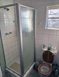 a bathroom with a toilet and a glass shower at @20401 in Gaborone
