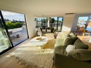 uma sala de estar com um sofá e uma mesa em Deluxe Downtown Mount Maunganui em Mount Maunganui
