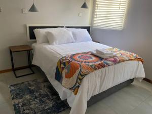 a bedroom with a large bed with a blanket on it at @20401 in Gaborone