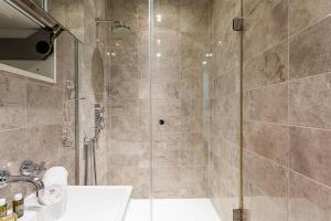 a bathroom with a shower and a sink at Holborn Flat with Green Views in London