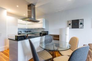 a kitchen with a glass table and chairs at Holborn Flat with Green Views in London