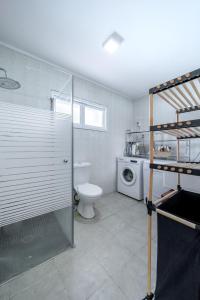 a bathroom with a toilet and a washing machine at Spacious 4BD House w Pool in the Heart of Herzliya by Sea N' Rent in Herzliya B