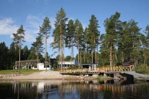 eine Holzbrücke über einen Wasserkörper mit Bäumen in der Unterkunft Hotelli Viikinhovi in Keuruu