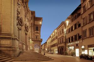 eine leere Straße mit Gebäuden und Treppen in einer Stadt in der Unterkunft Hotel De La Ville in Florenz