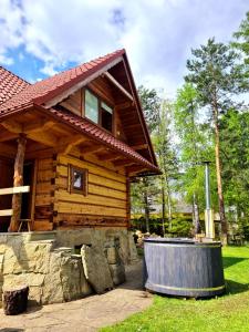a log cabin with a hot tub in front of it at Domek w Brzezowej 