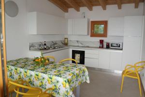 a kitchen with a table and yellow chairs in a kitchen at Casa del Codirosso in Gargnano