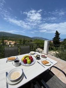 uma mesa com um prato de frutas e pão em Marina Studios em Sami