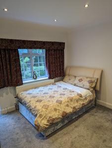 a bedroom with a large bed in front of a window at Home in Alwoodley, Leeds