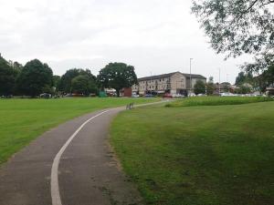 a winding road in a grassy field with a building at Home in Adel