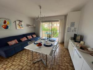 uma sala de estar com um sofá azul e uma mesa em Appartement proche mer - Narbonne Plage 4LP2A5 em Narbonne Plage