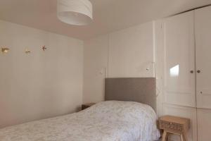Belle époque في غرانفيل: غرفة نوم بيضاء مع سرير وطاولة