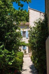 an alley in front of a white house at Hôtel LA MARGELLE in Pernes-les-Fontaines