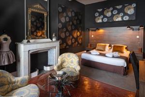 1 dormitorio con 1 cama y chimenea en Hôtel LA MARGELLE en Pernes-les-Fontaines