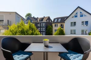 a table and chairs on a balcony with buildings at Uniklinik-Nähe Modernes Apartment, mit Balkon in Wuppertal