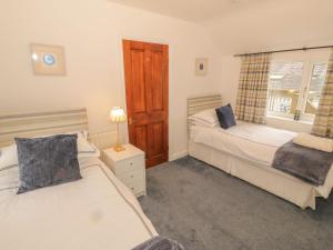 a bedroom with two beds and a window at Harlech View in Criccieth