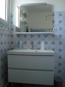 uma casa de banho com um lavatório branco e um espelho. em Appartement proche mer - Narbonne Plage 4LP2A5 em Narbonne Plage