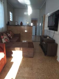 Hostel Bimba Goiânia - Unidade 01 في غويانيا: غرفة معيشة مع أريكة وتلفزيون بشاشة مسطحة