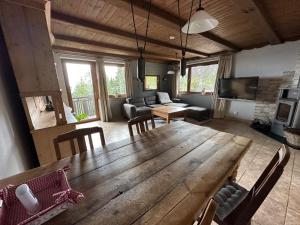 a large wooden table and chairs in a living room at Haus Weitblick in Sirnitz-Sonnseite