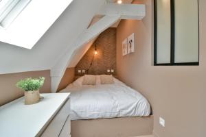 - une petite chambre mansardée avec un lit blanc dans l'établissement Résidence Jean Hardy - Hyper centre, parking gratuit, wifi, clim, gare, à Valenciennes