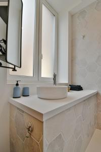 W łazience znajduje się umywalka i lustro. w obiekcie Résidence Jean Hardy - Hyper centre, parking gratuit, wifi, clim, gare w mieście Valenciennes
