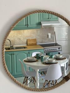 een keuken met groene kasten en een tafel met stoelen bij Afiartis Avli House in Karpathos