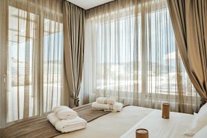 una camera da letto con asciugamani bianchi su un letto con finestra di Orelia Luxury Villas ad Amoopi