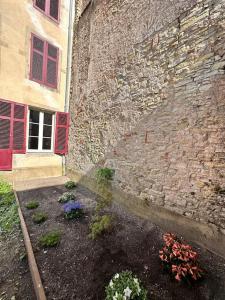 ein Steingebäude mit einem Garten davor in der Unterkunft Le Jardin de Léopold in Lunéville