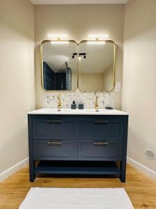 ein Badezimmer mit einer blauen Kommode und einem Spiegel in der Unterkunft Le Jardin de Léopold in Lunéville