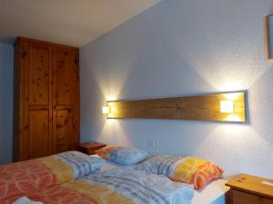 a bedroom with a bed and a light on the wall at B&B Alpenrösli in Gasenried