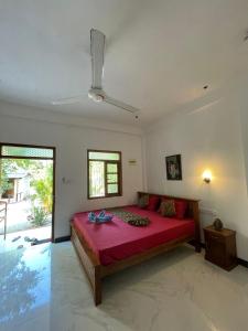 a bedroom with a large red bed in a room at Ubay Guest House in Trincomalee