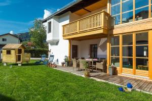 a house with a deck and a backyard at Ferienhaus Am Steinbach in Ruhpolding