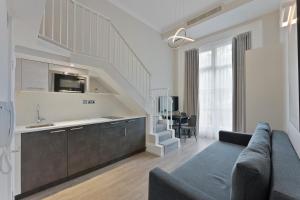 伦敦Cleveland Residences Paddington的带沙发的客厅、厨房和楼梯