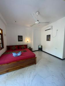 a bedroom with a large red bed with a ceiling at Ubay Guest House in Trincomalee