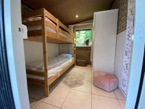 ein Zimmer mit zwei Etagenbetten und einem Fenster in der Unterkunft De Lavendeltuin in Sint Maartensvlotbrug