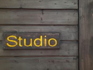 un cartel en una pared de madera con la palabra estudio en Studio en Letterkenny