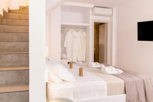 een witte slaapkamer met witte handdoeken op een bed bij Orelia Luxury Villas in Amoopi