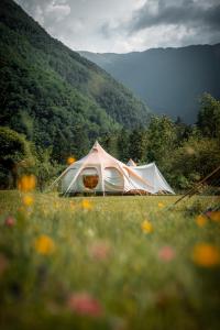 ein weißes Zelt auf einem Blumenfeld in der Unterkunft Glamping Gozdna Jasa in Bovec