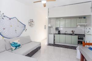 a living room with a couch and a kitchen at Arien in Cala en Blanes