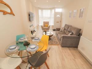 a living room with a glass table and chairs at Bay View in Criccieth