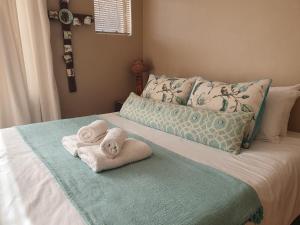 ein Bett mit Handtüchern darüber mit in der Unterkunft Affieplaas Selfsorg in Kimberley