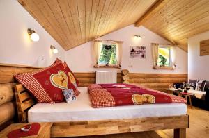 een slaapkamer met een bed met rode kussens bij Chalet Blumental in Neuschönau